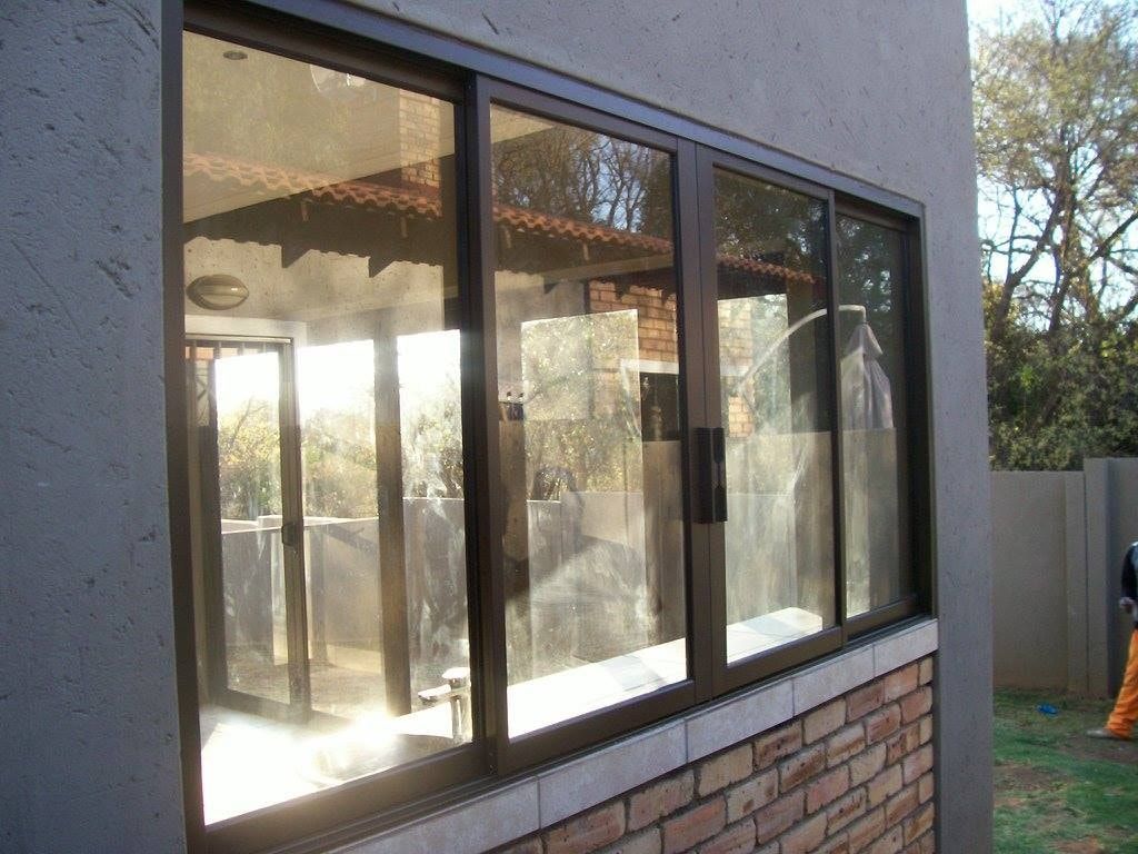 Bronze aluminium sliding window fitted in a plastered wall